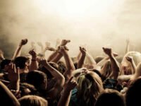 pessoas reunidas com as mãos para cima